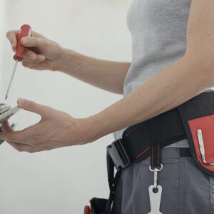 Female electrician fixing a socket at home